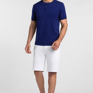 Model wearing Morning Surf Deep Sea Blue Icy Cotton® short sleeve soft henley, styled with white shorts