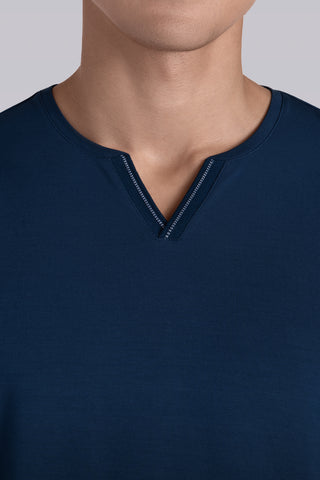 Model wearing Zen Lagoon Blue Icy Bamboo® long sleeve crewneck t-shirt, styled with grey pants.