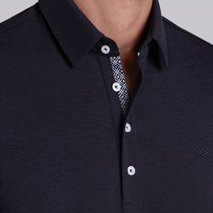 Model wearing Clubhouse Charcoal Icy Cotton® short sleeve polo, styled with light grey pants.