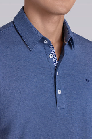 Model wearing Clubhouse Vintage Blue Icy Cotton® short sleeve polo, styled with white pants.