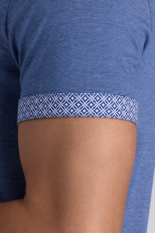 Model wearing Clubhouse Vintage Blue Icy Cotton® short sleeve polo, styled with white pants.