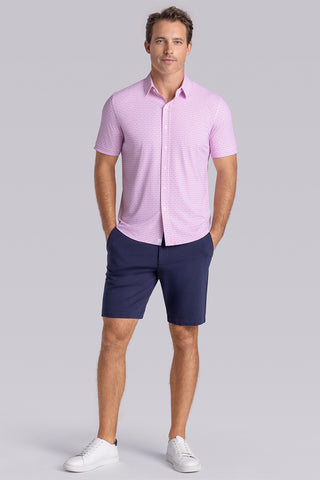 Model wearing Rhythm Raspberry Sorbet 6-Way Knit® short sleeve casual shirt with collar placket, styled with navy shorts.