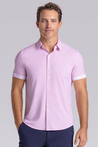 Model wearing Rhythm Raspberry Sorbet 6-Way Knit® short sleeve casual shirt with collar placket, styled with navy shorts.