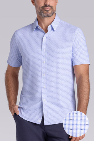 Model wearing Rhythm Santorini Blue 6-Way Knit® short sleeve casual shirt with collar placket, styled with navy shorts.