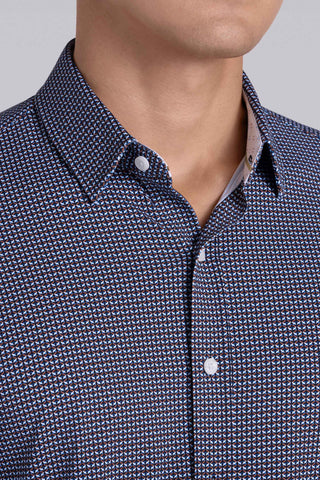 Model wearing Spry Navy Taupe long sleeve shirt with built in classic collar with geometric print, styled with jeans pants.
