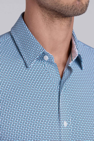 Model wearing Spry Seafoam long sleeve shirt with built in classic collar with geometric print, styled with jeans pants.