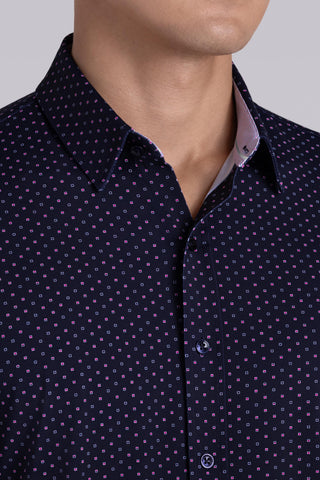 Model wearing Committed Navy Pink long sleeve shirt with built in classic collar with geometric print, styled with jeans.