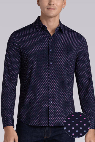 Model wearing Committed Navy Pink long sleeve shirt with built in classic collar with geometric print, styled with jeans.