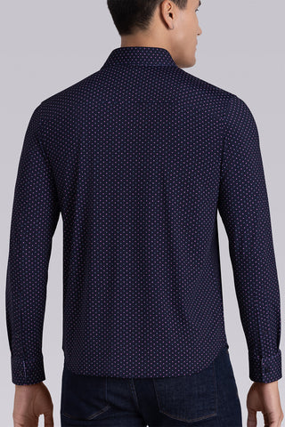 Model wearing Committed Navy Pink long sleeve shirt with built in classic collar with geometric print, styled with jeans.