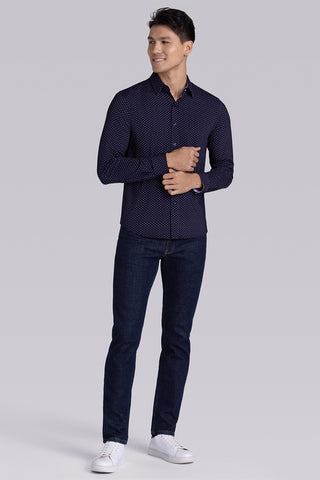 Model wearing Committed Navy Pink long sleeve shirt with built in classic collar with geometric print, styled with jeans.