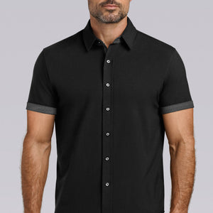 Model wearing Iconic Rapport Black short sleeve classic collar shirt, styled with grey pants