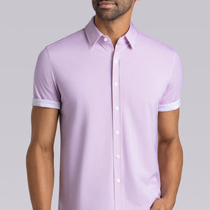 Model wearing Optimism Magenta short sleeve button-up shirt, styled with gray pants